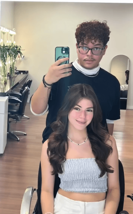 Cliente com ondas longas finalizadas pelo cabeleireiro no salão